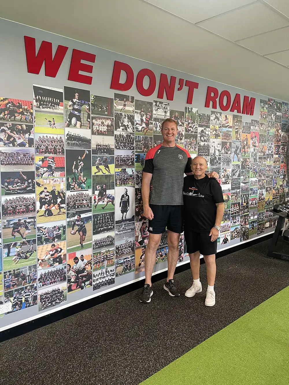 Emmanuel and Head Coach Cam Treloar in front of the West Harbour Rugby Signage